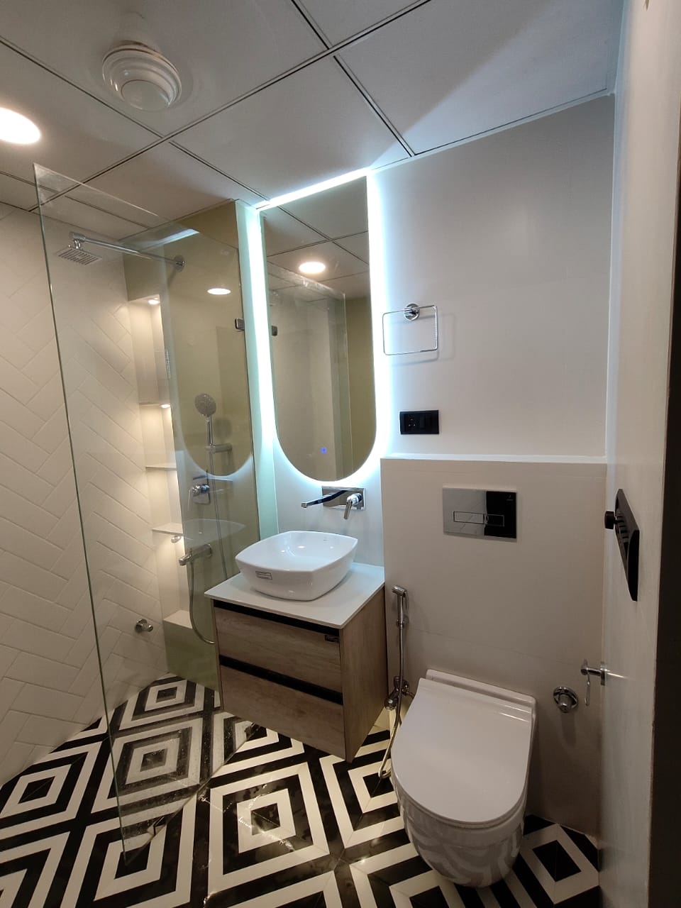 Finished bathroom with geometric floor tiles and glass shower