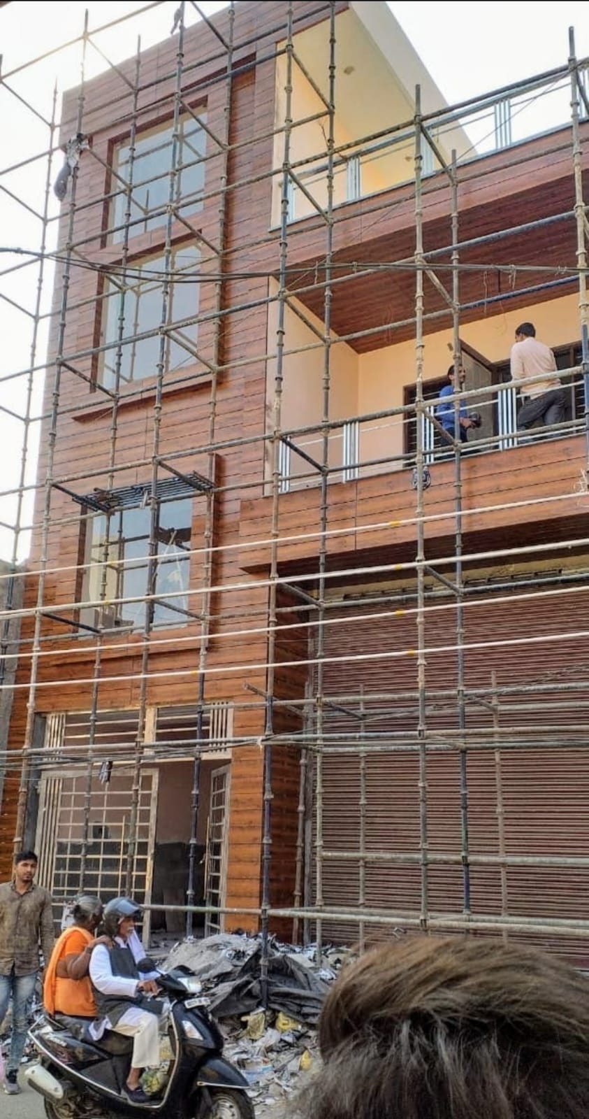 Residential building facade with wood cladding finishing work in progress