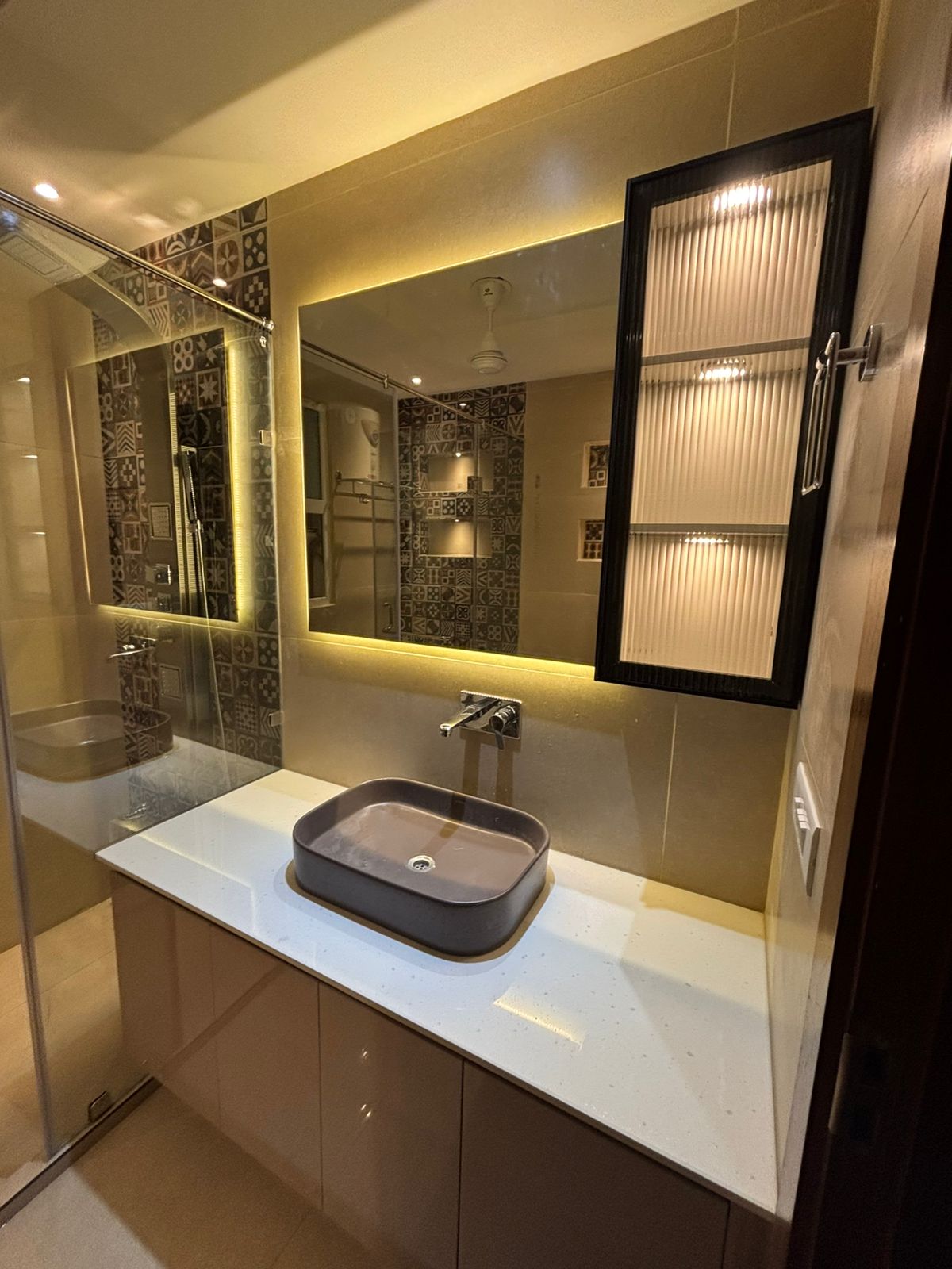 Luxury finished bathroom with grey vessel sink and glass shower