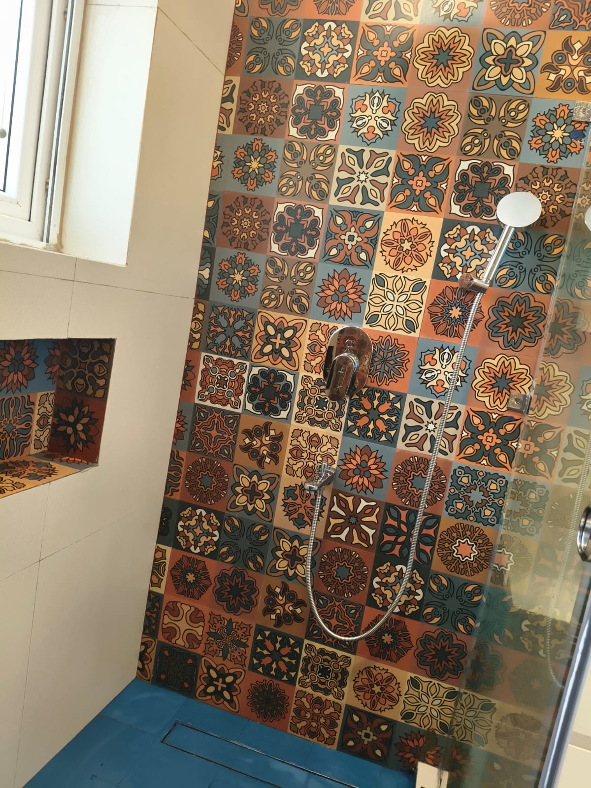 Shower area with designer tiles and hand shower fitting